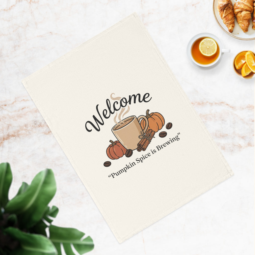 Printify Pumpkin Spice Is Brewing Cotton Tea Towel, off-white, with a steaming mug, pumpkins, cinnamon sticks, and coffee beans, with "Welcome" and "Pumpkin Spice is Brewing" text.