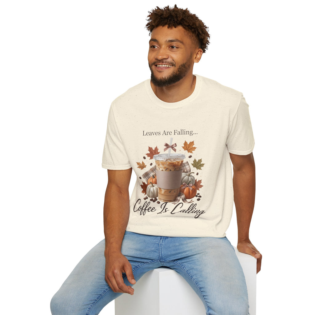 Man wearing a cream-colored "Leaves Are Falling... Coffee Is Calling" t-shirt with an iced latte, pumpkins, and autumn leaves graphic.