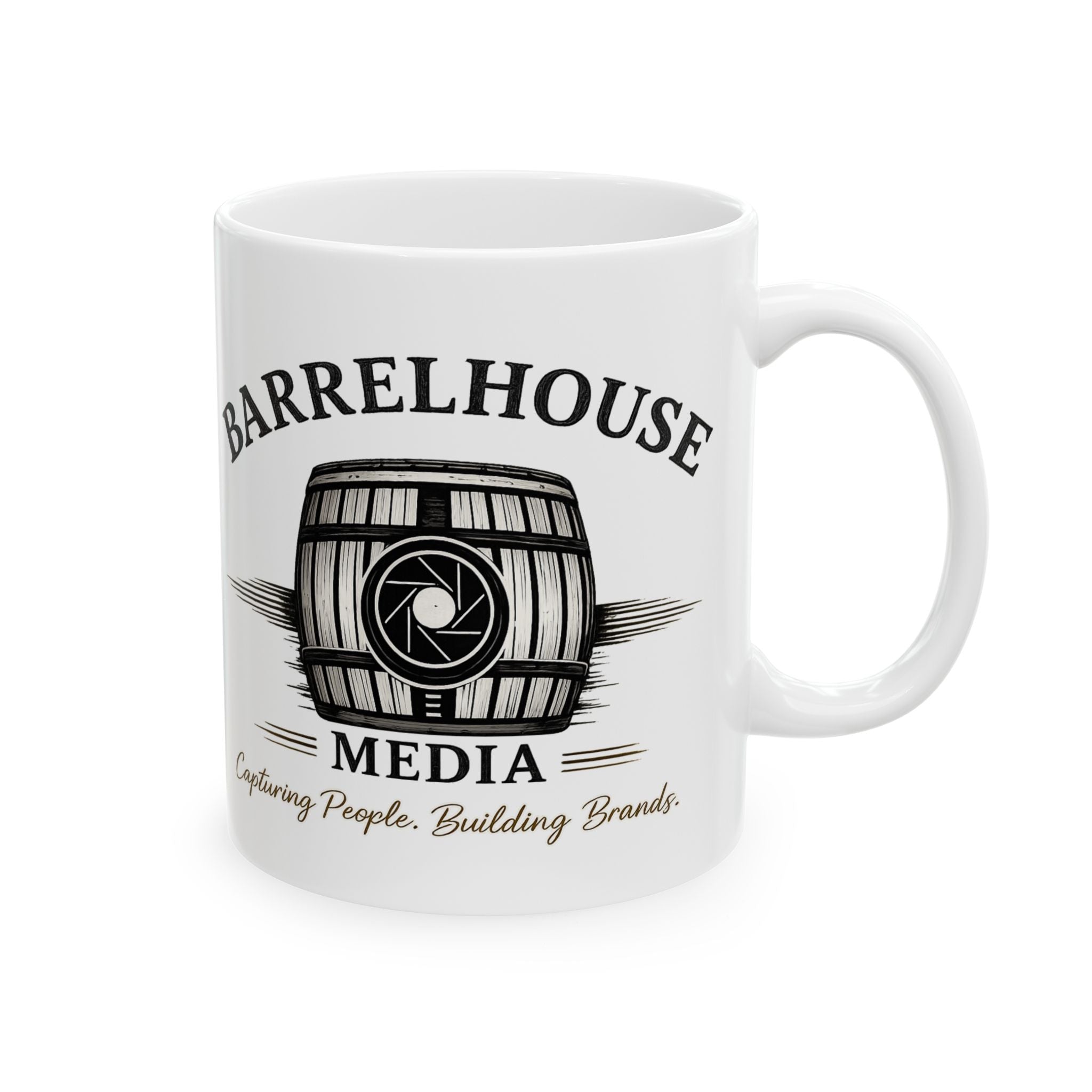 Front view of a white ceramic Barrelhouse Media coffee mug with a black and gold barrel logo.