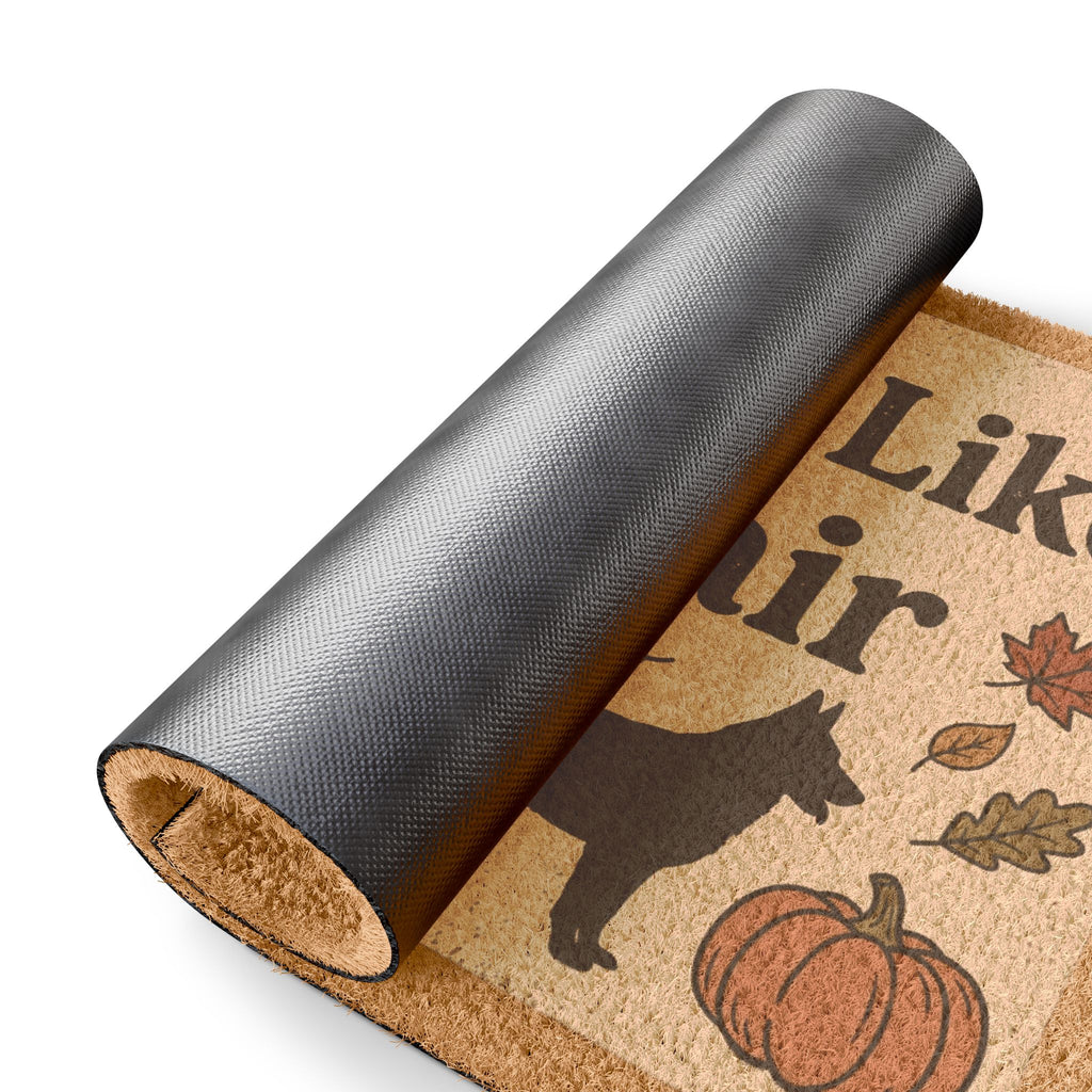 Close-up of a rolled-up "Hope You Like Dog Hair" doormat with a pumpkin, leaves, and dog silhouette.