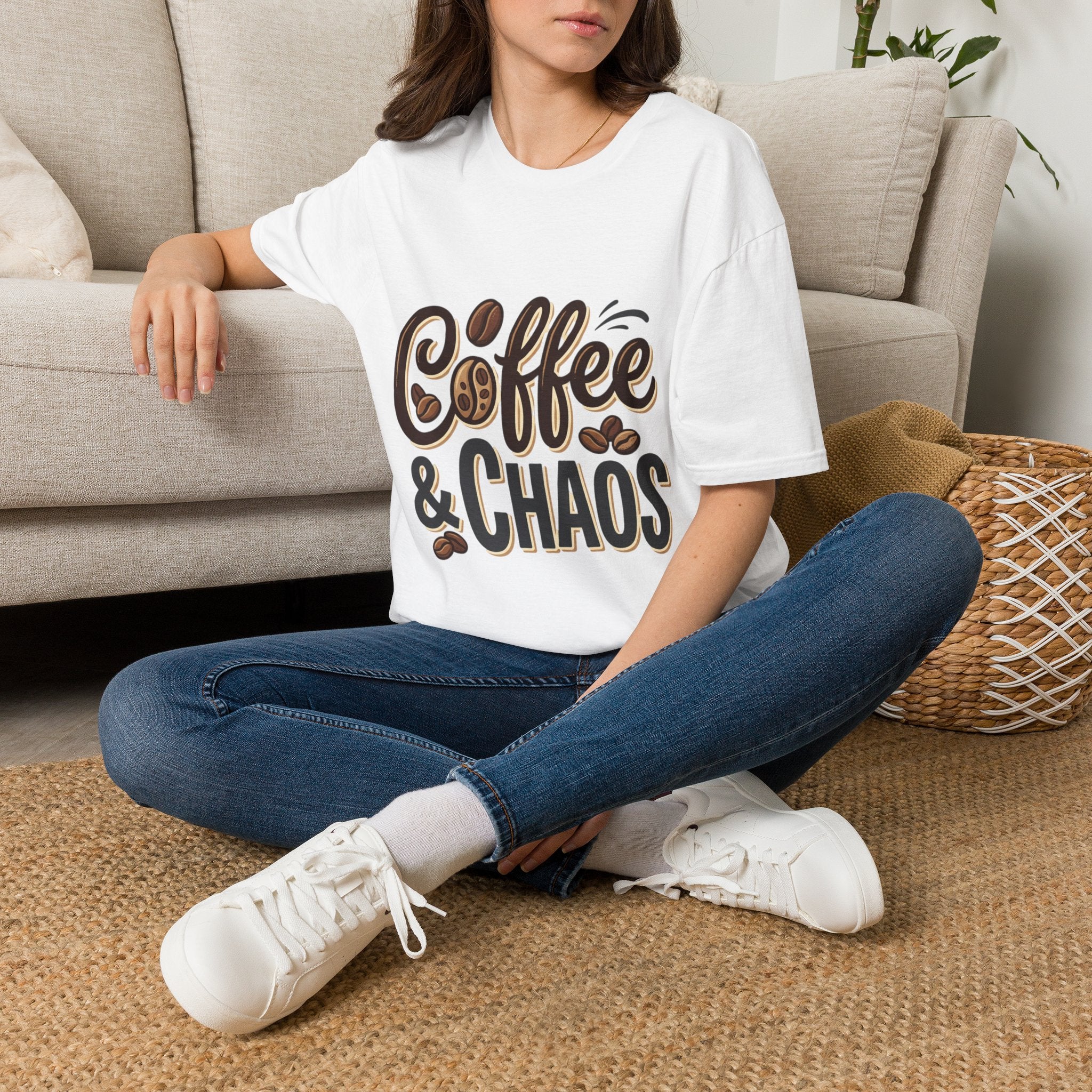 Front view of a woman wearing a white "Coffee & Chaos" t-shirt with brown lettering and coffee bean graphics.